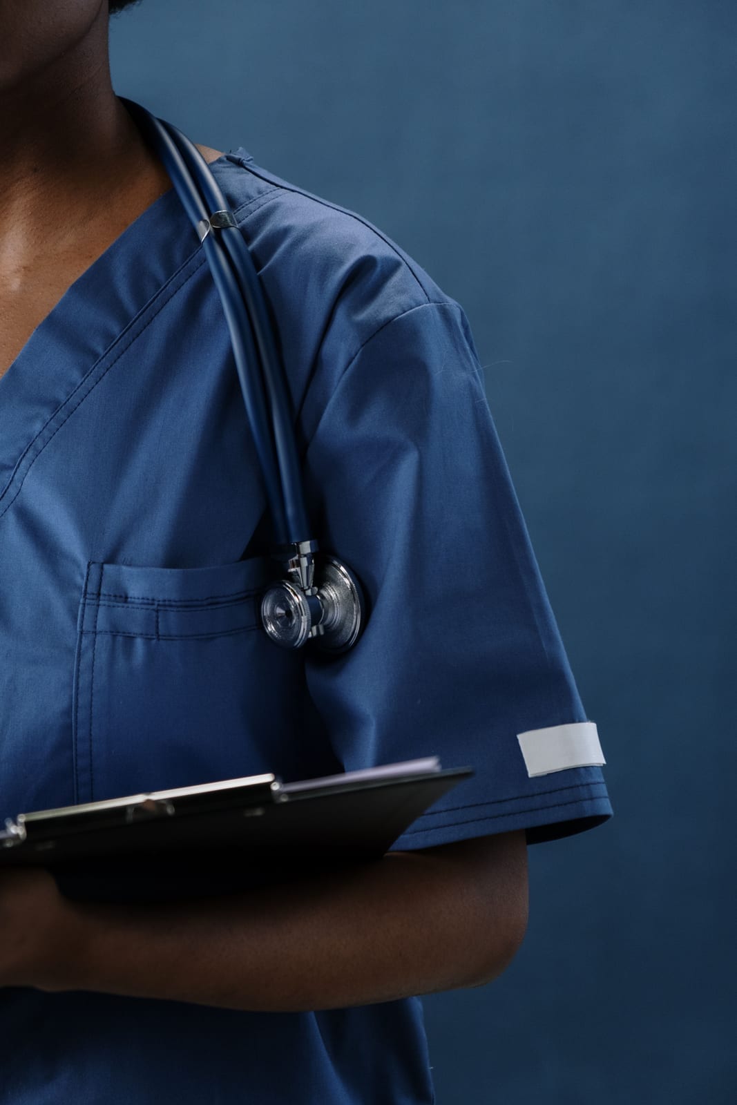 Close-up of a healthcare professional in scrubs with a stethoscope and clipboard