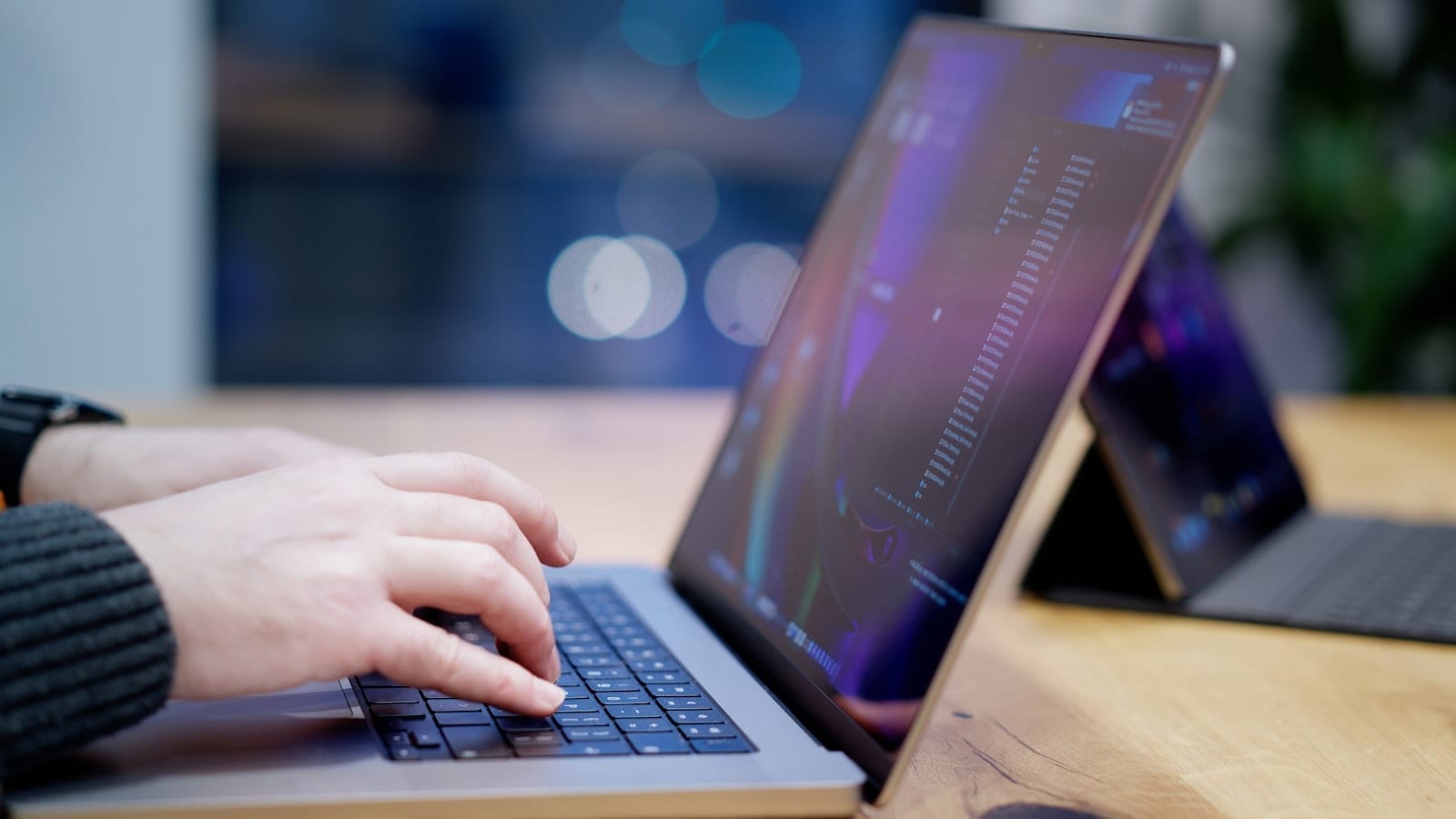 A person typing on a laptop at a desk