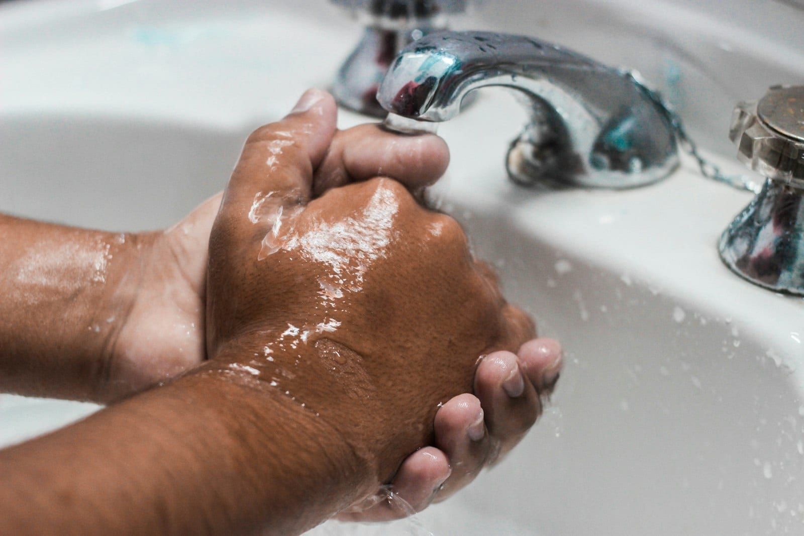 A person washing their hands at a sink