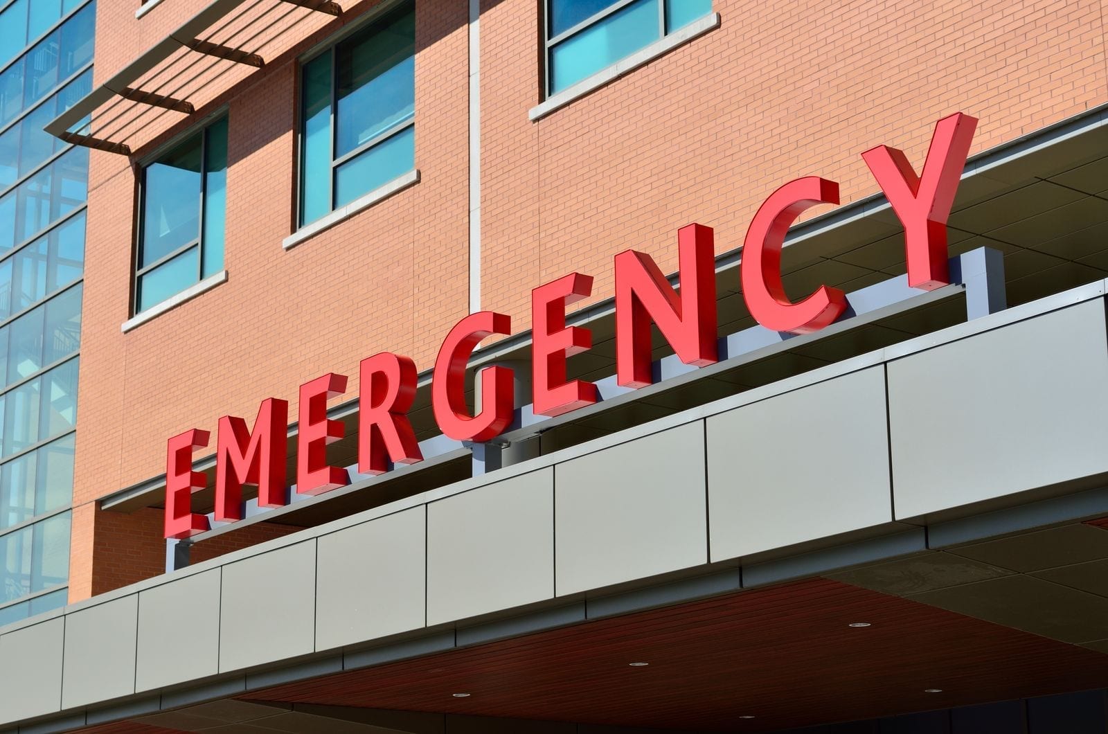 A modern hospital emergency room entrance with illuminated signage